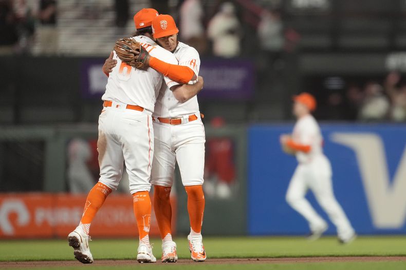 Casey Schmitt (izquierda) y Thairo Estrada festejan la victoria de los Gigantes de San Francisco sobre los Filis de Filadelfia, el martes 16 de mayo de 2023 (AP Foto/Jeff Chiu)