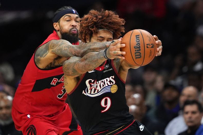 Kelly Oubre Jr., derecha, de los 76ers de Filadelfia, y Brandon Ingram, de los Raptors de Toronto, disputan el balón durante la segunda mitad del juego de baloncesto de la NBA el sábado 8 de noviembre de 2025, en Filadelfia. (AP Foto/Matt Slocum)
