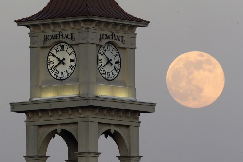 La Luna vista detrás de la torre de Home Place, el sábado 22 de junio de 2013, en Prattville, Alabama. (AP Foto/Dave Martin, Archivo)