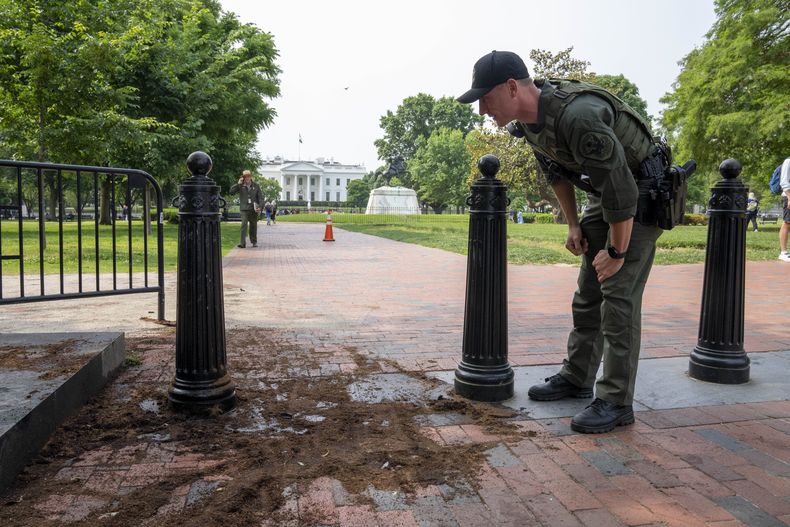 Un agente de la Policía Federal de Parques inspecciona el martes 23 de mayo de 2023 los daños causados a una barrera de seguridad en la Plaza Lafayette, contra la que se estrelló un camión de mudanzas la noche anterior, cerca de la Casa Blanca. (AP Foto/Alex Brandon)