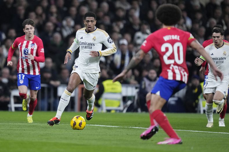 Jude Bellingham, centro, del Real Madrid, controla el balón durante el partido de La Liga de España entre Real Madrid y Atlético de Madrid en el estadio Santiago Bernabéu, en Madrid, España, el domingo 4 de febrero de 2024. (AP Foto/Bernat Armangue)