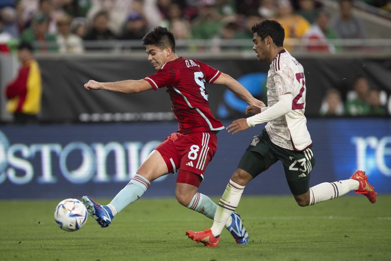 El volante colombiano Daniel Ruiz dispara frente al mediocampista mexicano Brian García, durante un partido amistoso en Los Ángeles, el sábado 16 de diciembre de 2023 (AP Foto/Kyusung Gong)