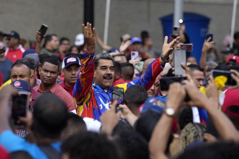 ARCHIVO - El presidente de Venezuela, Nicolás Maduro, saluda a jóvenes partidarios en una marcha contra sanciones estadounidenses en Caracas, Venezuela, el 17 de mayo de 2024. Mientras Maduro busca la reelección ante una base dividida, reducida y decepcionada, se ha convertido poco a poco en un defensor de los migrantes que cuestiona los reportes que vinculan a algunos con actividades criminales y acusa a las autoridades migratorias de otros países de maltratar a los venezolanos. (AP Foto/Ariana Cubillos, Archivo)