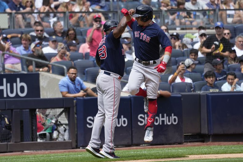 Luis Urías de los Medias Rojas de Boston celebra con el entrenador de tercera base Carlos Febles tras pegar un grand slam en la segunda entrada del encuentro ante los Yanquis de Nueva York el sábado 19 de agosto del 2023.. (AP Foto/Mary Altaffer)