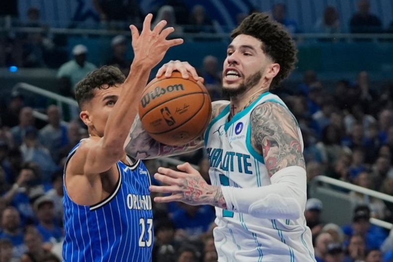 LaMelo Ball, derecha, de los Hornets de Charlotte, intenta colarse hacia la canasta frente a Tristan da Silva (23), del Magic de Orlando, durante la segunda mitad del juego de baloncesto de la NBA en el play-in, el viernes 17 de abril de 2026, en Orlando, Florida. (AP Foto/John Raoux)