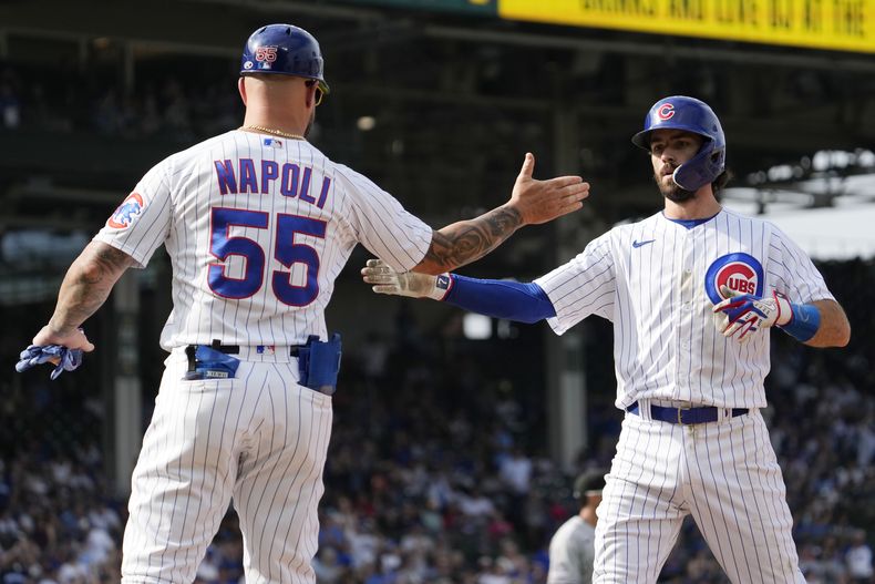Dansby Swanson, derecha, de los Cachorros de Chicago, celebra con el coach de primera base Mike Napoli (55) después de batear sencillo productor de una carrera en la séptima entrada del juego de béisbol en contra de los Rockies de Colorado, el viernes 22 de septiembre de 2023. (AP Foto/Nam Y. Huh)