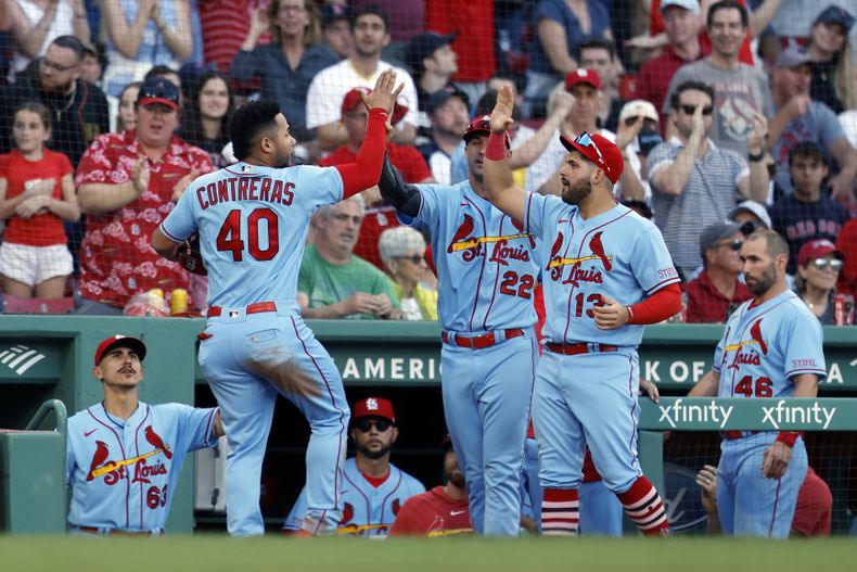 El venezolano Willson Contreras, de los Cardenales de San Luis, festeja con su compatriota Juan Yepez (13) y con Jack Flaherty (22) luego de anotar ante los Medias Rojas de Boston el sábado 13 de mayo de 2023 (AP Foto/Michael Dwyer)