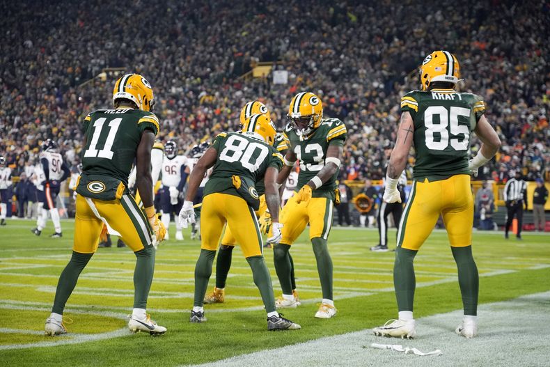 Dontayvion Wicks (13), wide receiver de los Packers de Green Bay, celebra con sus compañeros de equipo después de anotar un touchdown durante la segunda mitad del juego de la NFL en contra de los Bears de Chicago el domingo 7 de enero de 2024, en Green Bay, Wisconsin. (AP Foto/Morry Gash)