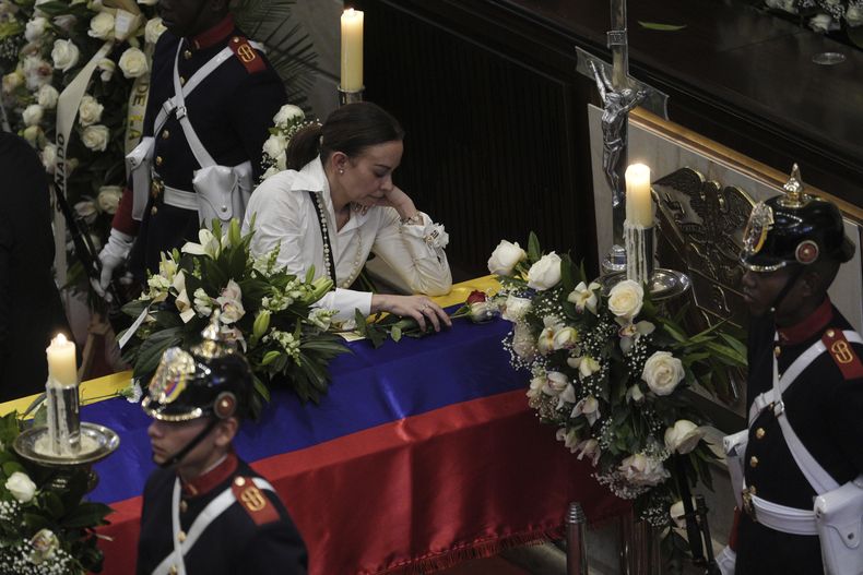 Claudia Tarazona se apoya en el ataúd de su esposo, el aspirante presidencial y senador opositor Miguel Uribe Turbay, quien murió a causa de las heridas sufridas cuando recibió un disparo en un mitin político, en el Congreso de Bogotá, Colombia, el martes 12 de agosto de 2025. (AP Foto/Iván Valencia)