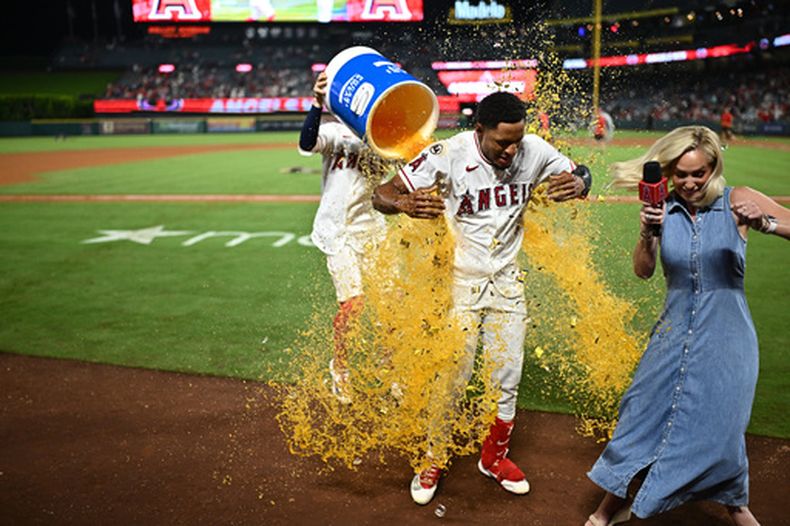 El jugador de los Angelinos de Los Ángeles, Christian Moore (centro), es bañado con un recipiente de hielo tras conectar un sencillo de oro en la undécima entrada de un partido de béisbol contra los Mellizos de Minnesota, el sábado 19 de septiembre de 2026, en Anaheim, California. (Foto AP/William Liang)