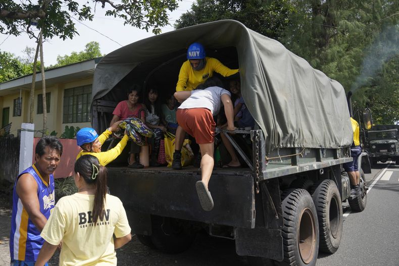 Residentes suben a un camión militar para evacuar sus casas en la localidad de Santo Domingo, en la provincia de Albay, en el noreste de Filipinas, por la erupción de un volcán, el 13 de junio de 2023. (AP Foto/Aaron Favila)