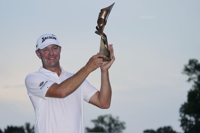 Lucas Glover alza el trofeo que lo acredita como ganador del torneo de golf St. Jude Championship, el domingo 13 de agosto de 2023, en Memphis, Tennessee. (AP Foto/George Walker IV)