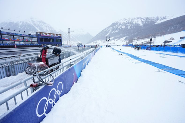 Un obrero despeja la nieve en una pista de competencia de los Juegos Olímpicos de Invierno, el miércoles 4 de febrero de 2026, en Livigno, Italia. (AP Foto/Gregory Bull)