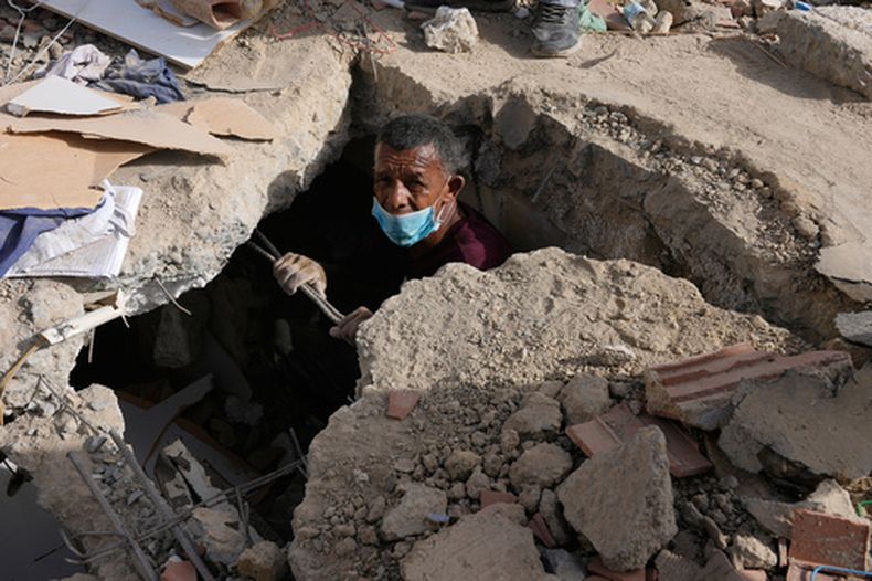 Franklin Fuentes busca a familiares desaparecidos en el edificio derrumbado donde vivían dos días después de que los terremotos azotaran La Guaira, Venezuela, el viernes 26 de junio de 2026. (AP Foto/Ariana Cubillos)