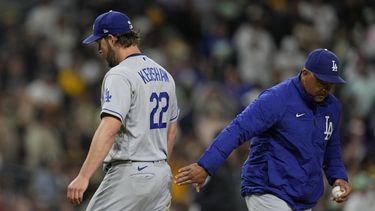 Dave Roberts, derecha, manager de los Dodgers de Los Ángeles, recibe la pelota de manos del lanzador Clayton Kershaw, izquierda, mientras éste sale del partido durante la quinta entrada, el viernes 5 de mayo de 2023, en San Diego. (AP Foto/Gregory Bull)