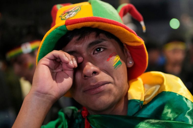 Un hincha boliviano llora la derrota de la selección de su país ante Irak, tras mirar el partido en una pantalla gigante en La Paz, la madrugada del miércoles 1 de abril de 2026 (AP Foto/Juan Karita)
