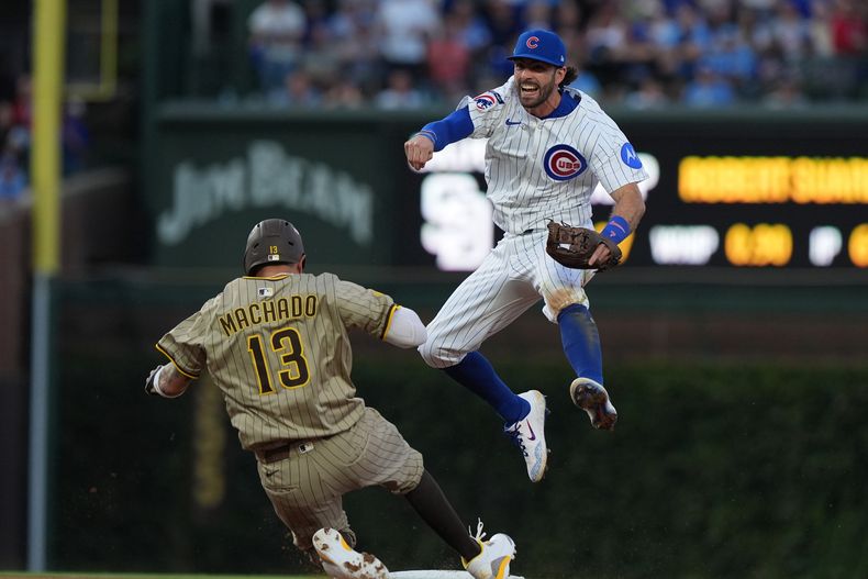 Dansby Swanson de los Cachorros de Chicago salta sobre Manny Machado de los Padres de San Diego en el tercer juego de la serie de comodines de la Liga Nacional, el jueves 2 de octubre de 2025, en Chicago. (AP Foto/Nam Huh)