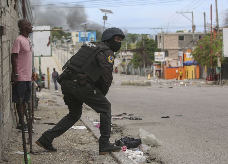Un policía mira durante un enfrentamiento a tiros entre pandillas y policías en Puerto Príncipe, Haití, el lunes 11 de noviembre de 2024. (AP Foto/Odelyn Joseph)