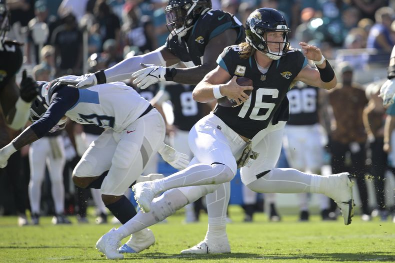 El quarterback Trevor Lawrence (16) de los Jaguars de Jacksonville avanza con el balón ante los Titans de Tennessee, el domingo 19 de noviembre de 2023. (AP Foto/Phelan M. Ebenhack)