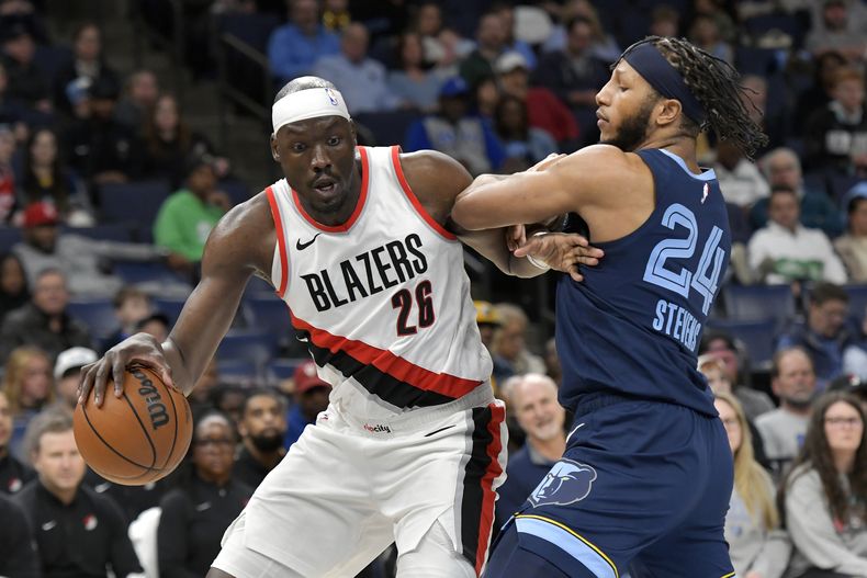 Duop Reath (26), de los Trail Blazers de Portland, maneja el balón en contra de Lamar Stevens (24), de los Grizzlies de Memphis, en la primera mitad del juego de baloncesto de la NBA, el viernes 1 de marzo de 2024, en Memphis, Tennessee. (AP Foto/Brandon Dill)