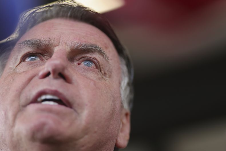 ARCHIVO - El expresidente Jair Bolsonaro habla con los medios de comunicación mientras llega al Aeropuerto Internacional de Brasilia, el 25 de marzo de 2025. (AP Foto/Luis Nova, Archivo)