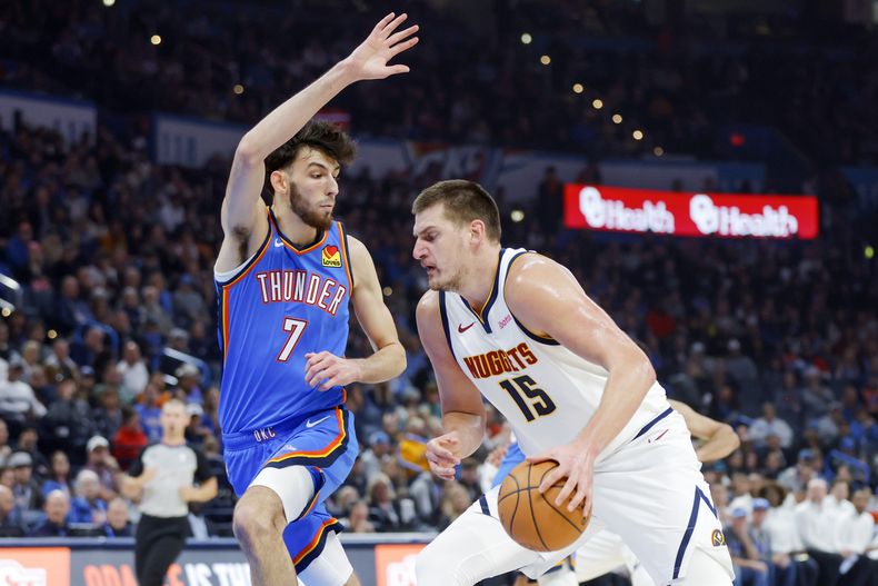 El pivot de los Nuggets de Denver Nikola Jokic avanza hacia la canasta frente al alero del Thunder de Oklahoma City Chet Holmgren en el encuentro de la NBA el domingo 29 de octubre del 2023. (AP Foto/Nate Billings)