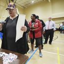 ARCHIVO - Blythe González, a la derecha, hace una pregunta a un trabajador del distrito electoral de Jackson, Mississippi, mientras su marido Jorge González, a la izquierda, espera con su papeleta, para acompañarla a un quiosco de votación, 5 de noviembre de 2024. (AP Rogelio V. Solis, archivo)