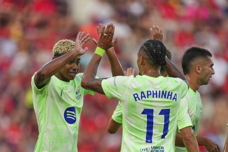 Lamine Yamal del Barcelona celebra con Raphinha tras anotar en el encuentro de La Liga ante el Mallorca el sábado 16 de agosto del 2024. (AP Foto/Joan Mateu Parra)