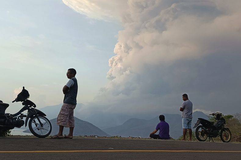 Unas personas ven al volcán Lewotobi Laki Laki hacer erupción en East Flores, Indonesia el 9 de noviembre de 2024. (AP Foto)