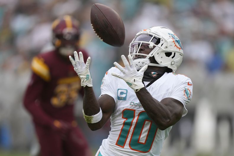 ARCHIVO - Foto del 3 de diciembre del 2023, el receptor de los Dolphins de Miami Tyreek Hill atrapa un pase de touchdown ante los Commanders de Washington. (AP Foto/Mark Schiefelbein, Archivo)