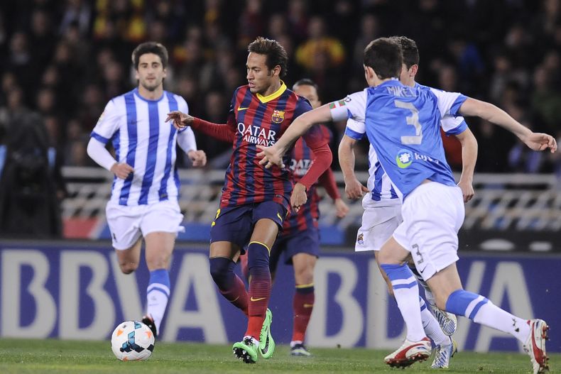 Neymar trata de filtrarse entre varios rivales de Real Sociedad el 22 de febrero del 2014 en San Sebasti&aacute;n, Espa&ntilde;a. Barcelona abon&oacute; 13,5 millones de euros al fisco espa&ntilde;ol dos d&iacute;as despu&eacute;s, adelant&aacute;ndose al