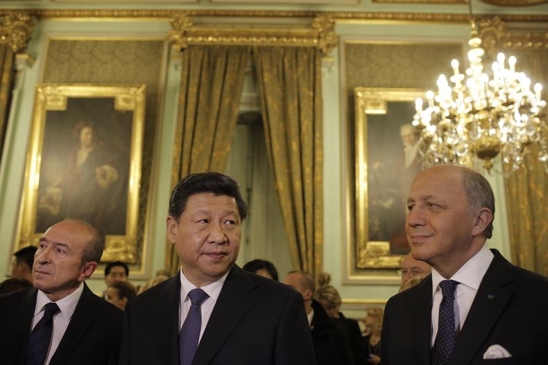 El presidente chino Xi Jinping (centro), el alcalde de la ciudad de Lyon Gerard Collomb (izquierda) y el ministro de Exteriores de Francia Laurent Fabius aparecen antes de una cena en honor del mandatario de China el martes 25 de marzo de 2014. Xi Jinping
