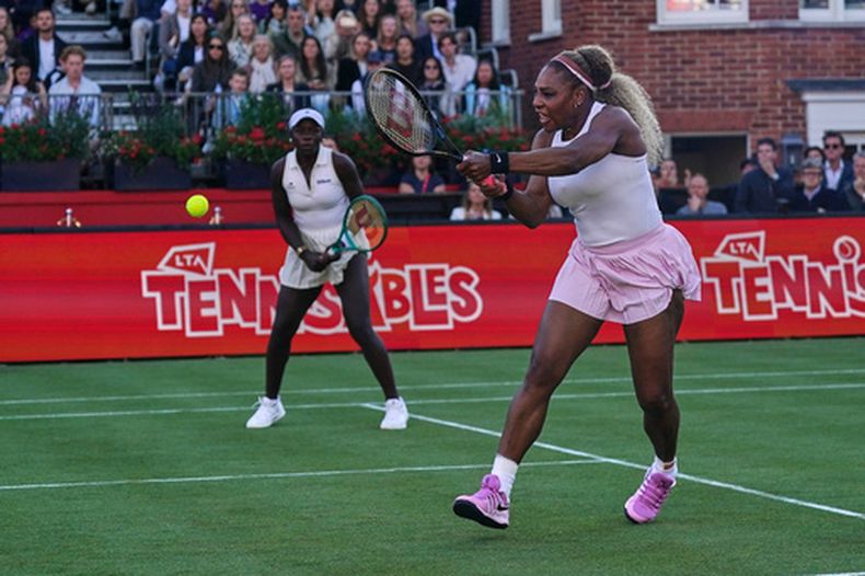 La estadounidense Serena Williams regresa una bola junto a su compañera de dobles, la canadiense Victoria Mboko en el encuentro de dobles ante la canadiense Nicole Melichar-Martinez y la neozelandesa Erin Routliffe en el Queens Club tennis championships el martes 9 de junio del 2026. (AP Foto/Alberto Pezzali)