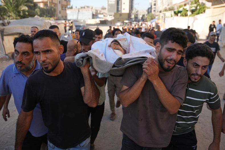 Un grupo de personas traslada el cuerpo de un palestino que murió en un ataque aéreo israelí, en Nuseirat, en el centro de la Franja de Gaza, el viernes 17 de julio de 2026. (Foto AP/Abdel Kareem Hana)