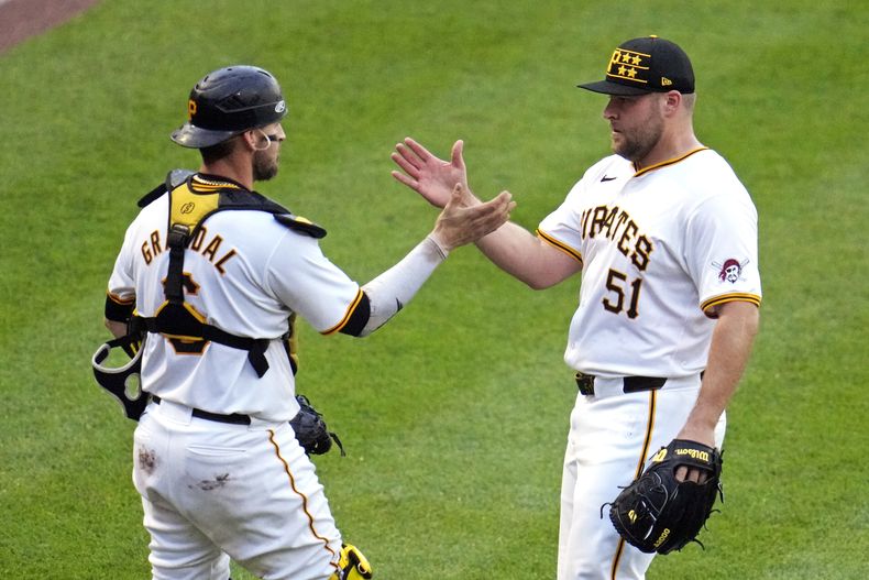 El relevista de los Piratas de Pittsburgh, David Bednar (51), celebra con el receptor Yasmani Grandal después de la victoria del equipo sobre los Bravos de Atlanta en el juego de béisbol en Pittsburgh, el sábado 25 de mayo de 2024. Los Piratas ganaron 4-1. (AP Foto/Gene J. Puskar)