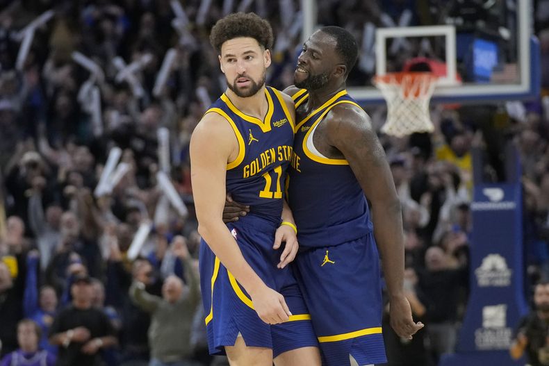 Klay Thompson, de los Warriors de Golden State, festeja con Draymond Green, luego de encestar ante los Kings de Sacramento en el partido del miércoles 1 de noviembre de 2023 (AP Foto/Jeff Chiu)