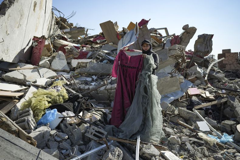 Nour Abu Al Zamar recupera algunos objetos de entre los escombros de su casa en Rafah, en la Franja de Gaza, el 21 de enero de 2025, días después de la entrada en vigor del acuerdo de alto el fuego entre Israel y Hamás. (AP Foto/Abdel Kareem Hana)