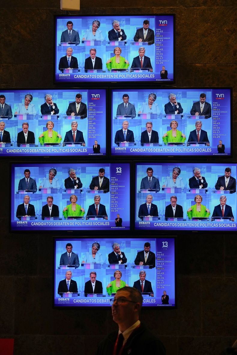 Los candidatos presidenciales para las próximas elecciones generales aparecen en pantallas de televisión durante un debate en un salón de Televisión Nacional de Chile en Santiago de Chile, el lunes 10 de noviembre de 2025. (Foto AP/Esteban Félix)