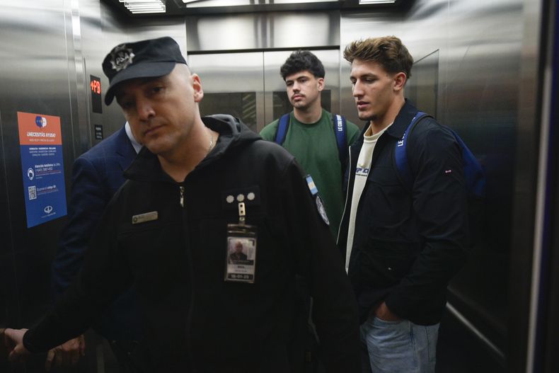 ARCHIVO - Los jugadores franceses de rugby Oscar Jegou (derecha) y Hugo Auradou (centro) toman un ascensor en el aeropuerto de Buenos Aires, el 3 de septiembre de 2024, luego que se les permitió salir de Argentina, durante una pesquisa por una presunta violación . (AP Foto/Gustavo Garello, archivo)