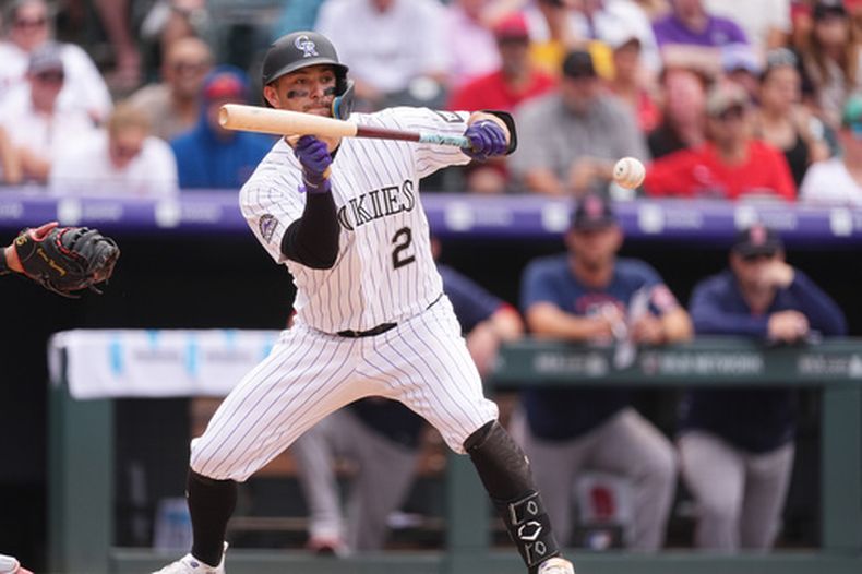 Tyler Freeman, de los Rockies de Colorado, toca la pelota para impulsar una carrera en la octava entrada ante el relevista de los Medias Rojas de Boston, Justin Slaten, en el juego de béisbol de Grandes Ligas del miércoles 24 de junio de 2026, en Denver. (AP Foto/David Zalubowski)
