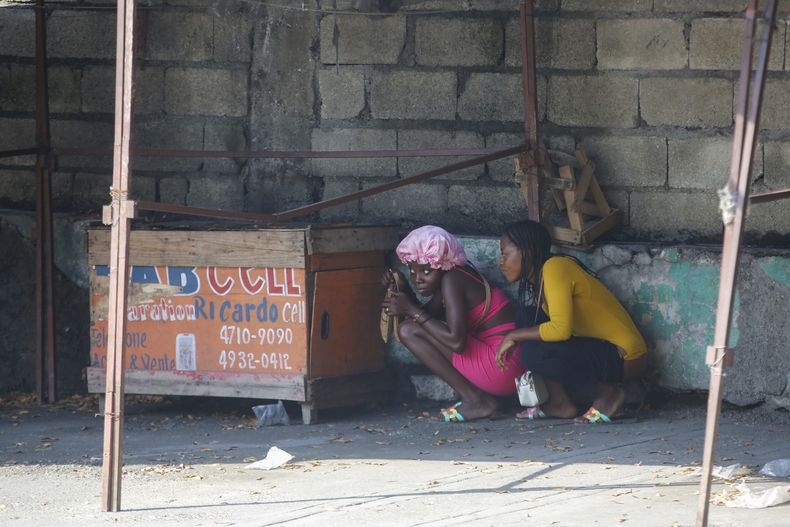 ARCHIVO - Mujeres se refugian durante un tiroteo entre la policía y pandilleros en Puerto Príncipe, Haití, el 1 de marzo de 2024. (AP Foto/Odelyn Joseph, Archivo)