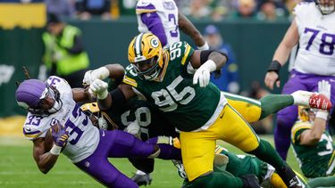 ARCHIVO - Aaron Jones Sr. (33), running back de los Vikings de Minnesota, es golpeado por Devonte Wyatt (95), tackle defensivo de los Packers de Green Bay, durante el partido de la NFL del 23 de noviembre de 2025, en Green Bay, Wisconsin. (AP Foto/Matt Ludtke, Archivo)