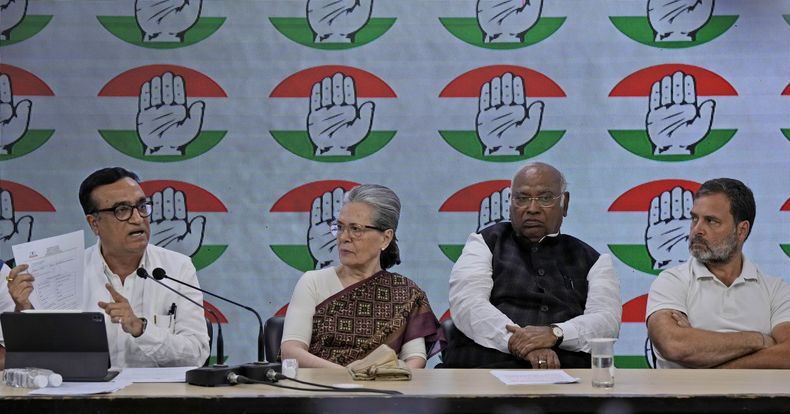 El tesorero del partido Congreso, Ajay Maken, a la izquierda, habla mientras muestra un aviso de la autoridad fiscal india, junto al presidente del partido, Mallikarjun Kharge, segundo por la derecha, y los miembros destacados Sonia Gandhi, segunda por la izquierda, y Rahul Gandhi durante una conferencia de prensa en Nueva Delhi, India, el jueves 21 de marzo de 2024. (AP Foto/Manish Swarup)