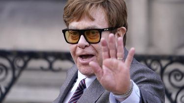 ARCHIVO - Elton John saluda a los medios de comunicación que esperan cuando sale de los Tribunales Reales de Justicia de Londres, el lunes 27 de marzo de 2023. (Foto AP/Alberto Pezzali, archivo)