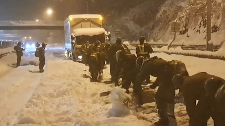 En esta imagen proporcionada por la Fuerza Terrestre de Autodefensa de Japón, sus soldados despejan nieve para que los vehículos puedan pasar por una autopista cerca o en Sekigahara, en el centro de japón, el miércoles 24 de enero de 2024. (Fuerza Terrestre de Autodefensa de Japón vía AP)