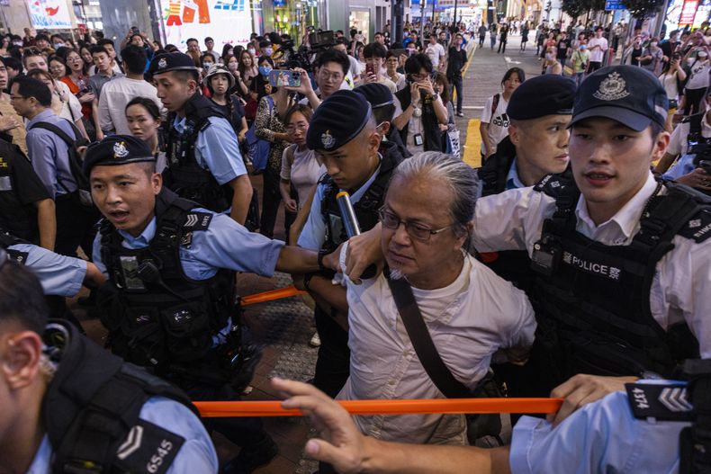 La policía se lleva a una persona en la zona de la bahía Causeway en Hong Kong, en vísperas del 34 aniversario de la masacre de la Plaza de Tiananmen en China, el sábado 3 de junio de 2023. (AP Foto/Louise Delmotte)