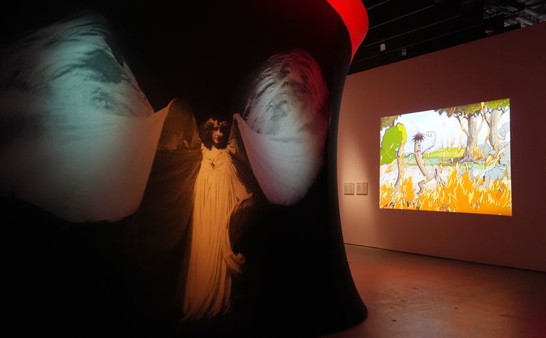 Una fotografía de la bailarina estadounidense Loie Fuller, izquierda, y el cortometraje de Walt Disney de 1932 Flowers and Trees en la exposición Color in Motion: Chromatic Explorations of Cinema (Color en Movimiento: Exploraciones Cromáticas del Cine) en el Museo de la Academia el martes 29 de octubre de 2024 en Los Angeles. (Foto AP/Chris Pizzello)