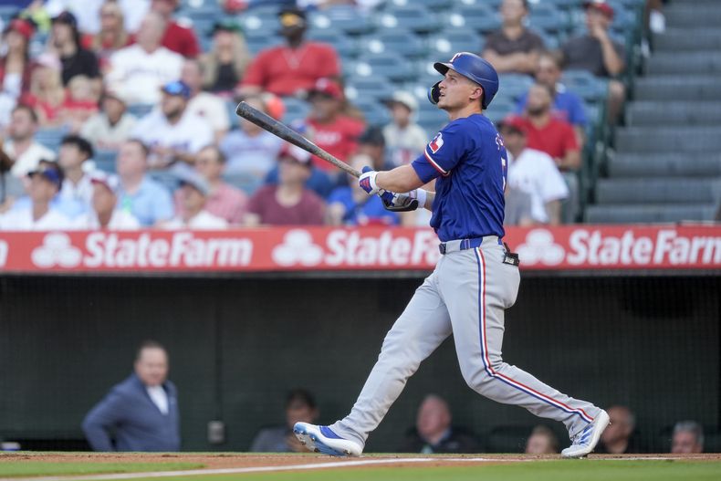Corey Seager, de los Rangers de Texas, observa su cuadrangular de dos carreras durante la primera entrada del juego de béisbol en contra de los Angelios de Los Ángeles, el lunes 8 de julio de 2024, en Anaheim, California. (AP Foto/Ryan Sun)