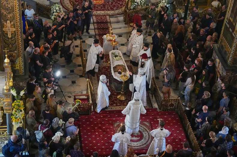 Sacerdotes ofician la ceremonia de despedida de Oleksiy Yukov —quien murió cuando exhumaba los cadáveres de soldados caídos en el frente de la región de Donetsk— en la catedral de San Vladimiro de Kiev, Ucrania, el sábado 8 de agosto de 2026. (Foto AP/Efrem Lukatsky)