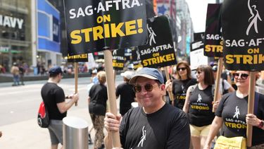 ARCHIVO - El actor Jason Kravits con un cartel en un mitin frente a Paramount en Times Square en Nueva York el 17 de julio de 2023. (Foto Charles Sykes/Invision/AP)